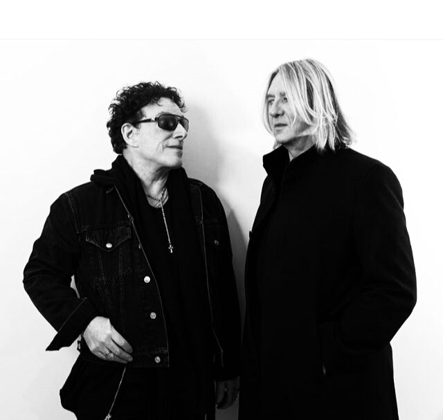 Neal Schon of Journey standing with Joe Elliott of def leppard discussing the tour 2018