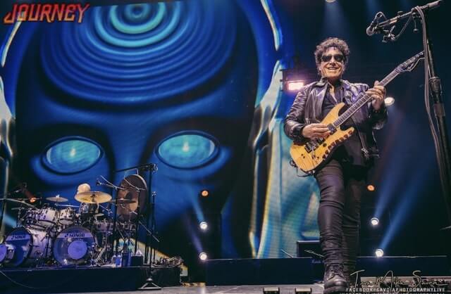 Neal Schon Guitar Legend plays Guitar on stage in front of blue robot head Variety of Pictures