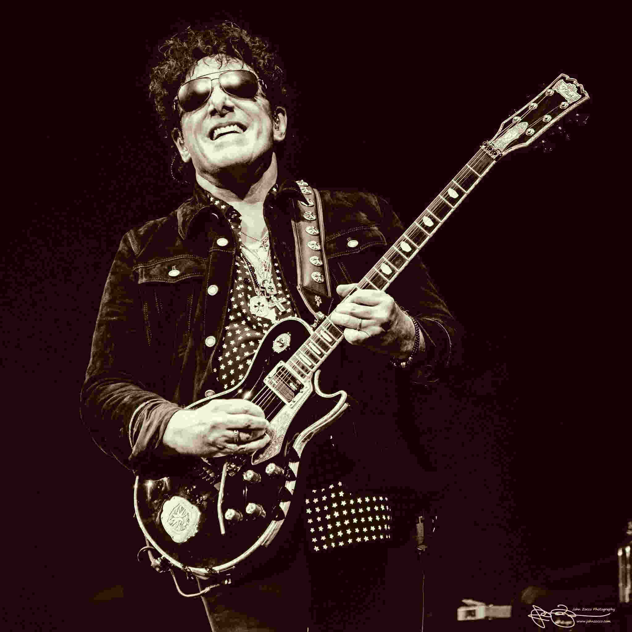 Neal Schon Plays Guitar Against a Black Backdrop Variety