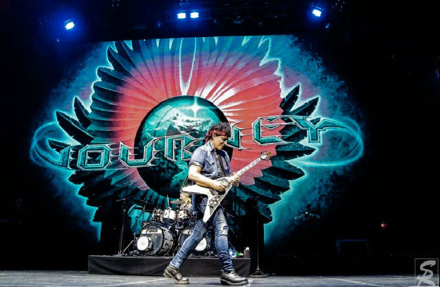 Neal Schon Guitar Legend excellent guitar playing in front of colorful backdrop Variety of Images Not ex Ava Fabian